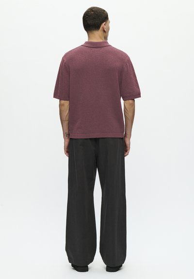 Polo cu mânecă scurtă, de culoare vișinie, cu o textură moale. Asortat cu pantaloni largi, de culoare închisă. Croială slim, cu un design clasic al gulerului.