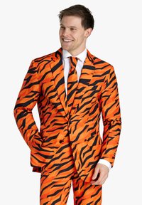 Completo tigre a strisce arancio e nero con cravatta coordinata. Presenta un giacca a due bottoni e pantaloni aderenti, progettato per un aspetto audace e vivace.
