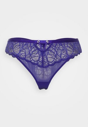 Paarse kanten string met doorschijnende panen, golvende randen en een decoratieve accent aan de voorkant met twee metalen lussen.