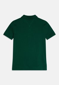 Camisa polo de color verde oscuro con cuello clásico, mangas cortas y un diseño trasero limpio sin logotipos ni adornos visibles.