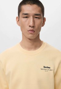 Geel katoenen sweatshirt met een ronde hals, met tekst en het "Barcelona"-logo aan de linkerkant. Gladde textuur en een losse pasvorm.