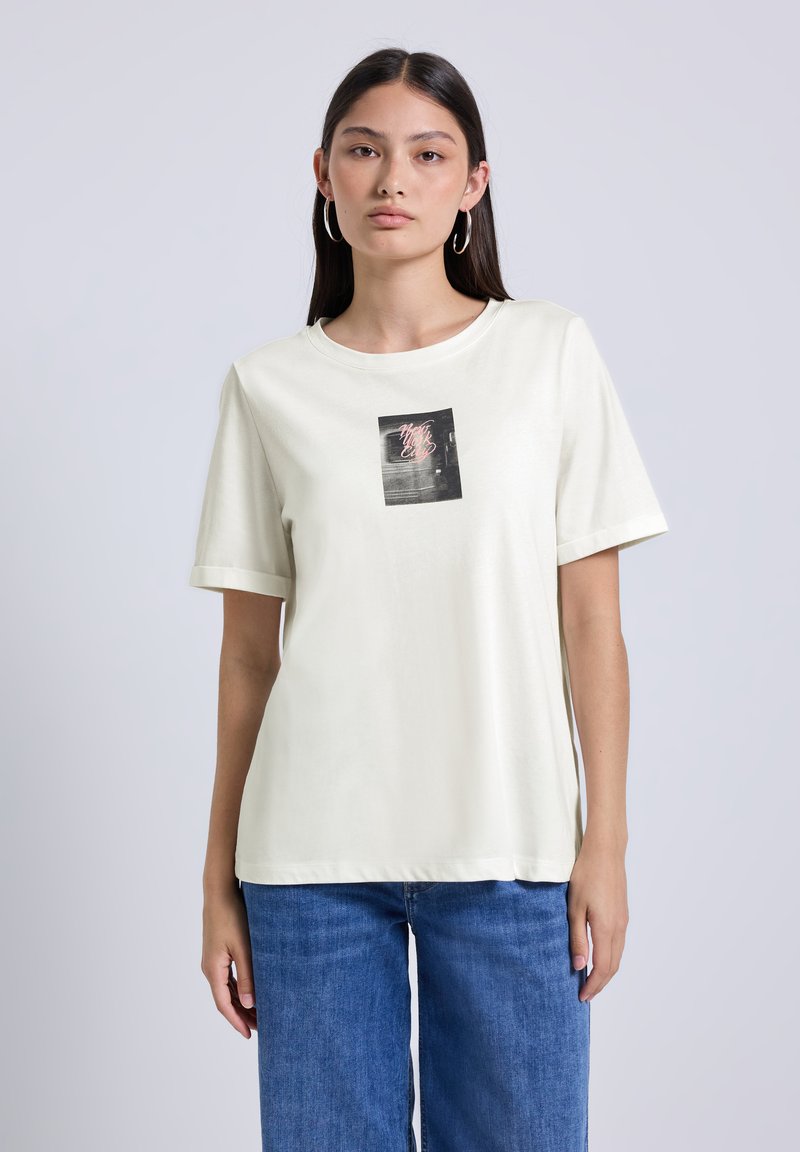 Lichtcrème t-shirt met korte mouwen en ronde halslijn, met een bedrukte print in zwart en roze in het midden. Zachte stofstructuur.
