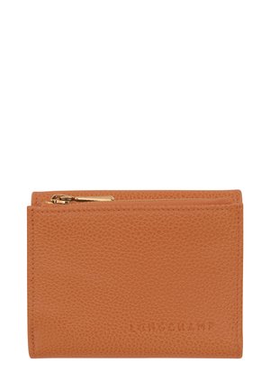 Tan leather wallet with a textured finish, featuring a zip closure and embossed logo detail on the front. Compact, rectangular design.