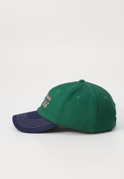 Casquette de baseball verte avec une visière bleu foncé, ornée de coutures blanches et de texte brodé à l'avant. Tissu en coton avec six trous de ventilation.