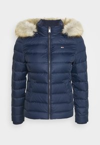 Navy blue quilted winter jacket with front zipper, two pockets, and a beige faux fur-lined hood.