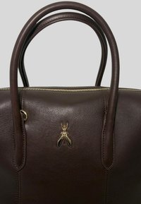 Borsa in pelle marrone scuro con manici arrotondati, zip dorata e un piccolo simbolo di insetto dorato al centro anteriore.