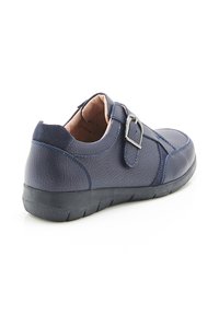 Chaussure en cuir bleu marine avec finition texturée, fixée par une boucle métallique et dotée d'une semelle en caoutchouc noir épaisse avec un motif de semelle.