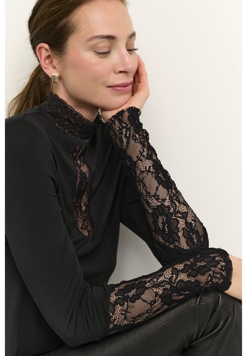 Black long-sleeve top featuring a lace high neckline and lace cuffs, with a form-fitting silhouette and smooth fabric texture.