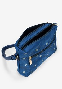 Borsa in nylon blu con due scomparti con cerniera, decorata con ricami dorati di fiori e schemi geometrici. Include una tracolla.