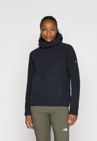 Marineblauwe fleece hoodie met hoge kraag, voorzak en contrasterende stiksels; soepele textuur en losse pasvorm.