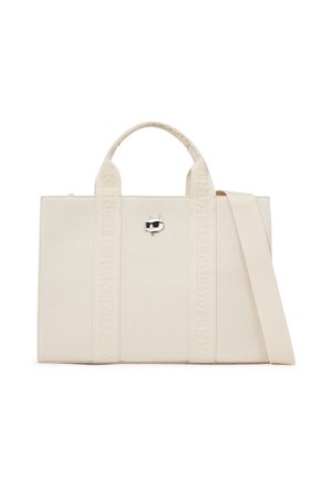 Sac fourre-tout rectangulaire beige avec deux poignées, une bandoulière amovible et un petit emblème de visage de chat avec des lunettes de soleil à l'avant.