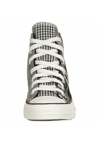Vysoké tenisky s černobílým kostkovaným vzorem, bílými tkaničkami a texturovanou gumovou podrážkou s černým akcentem.