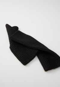 Sciarpa nera a coste in maglia con una texture morbida, caratterizzata da un design attorto. Il tessuto appare spesso e caldo, adatto per il clima freddo.