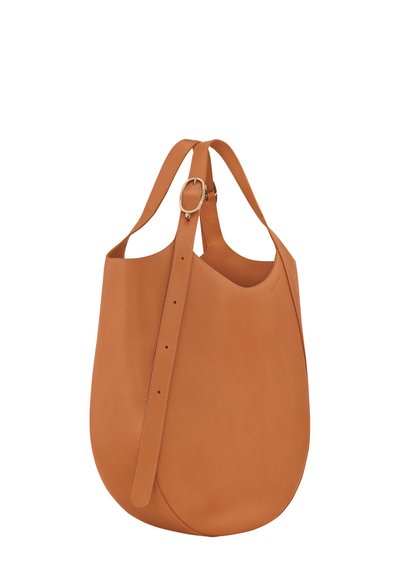 Tote-Bag aus braunem Leder mit glatter Oberfläche, weitem Öffnungsbereich und verstellbarem Tragegurt, der eine goldfarbene Schnalle und ein minimalistisches Design aufweist.