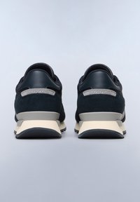 Black suede and leather shoes with a contrasting beige sole and grey accents. Features a padded collar and a metallic logo on the heel.