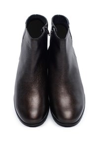 Brązowe skórzane botki za kostkę o gładkiej teksturze, z dekoracyjnymi zapięciami na zamek z przodu i okrągłym noskiem. Płaska podeszwa.