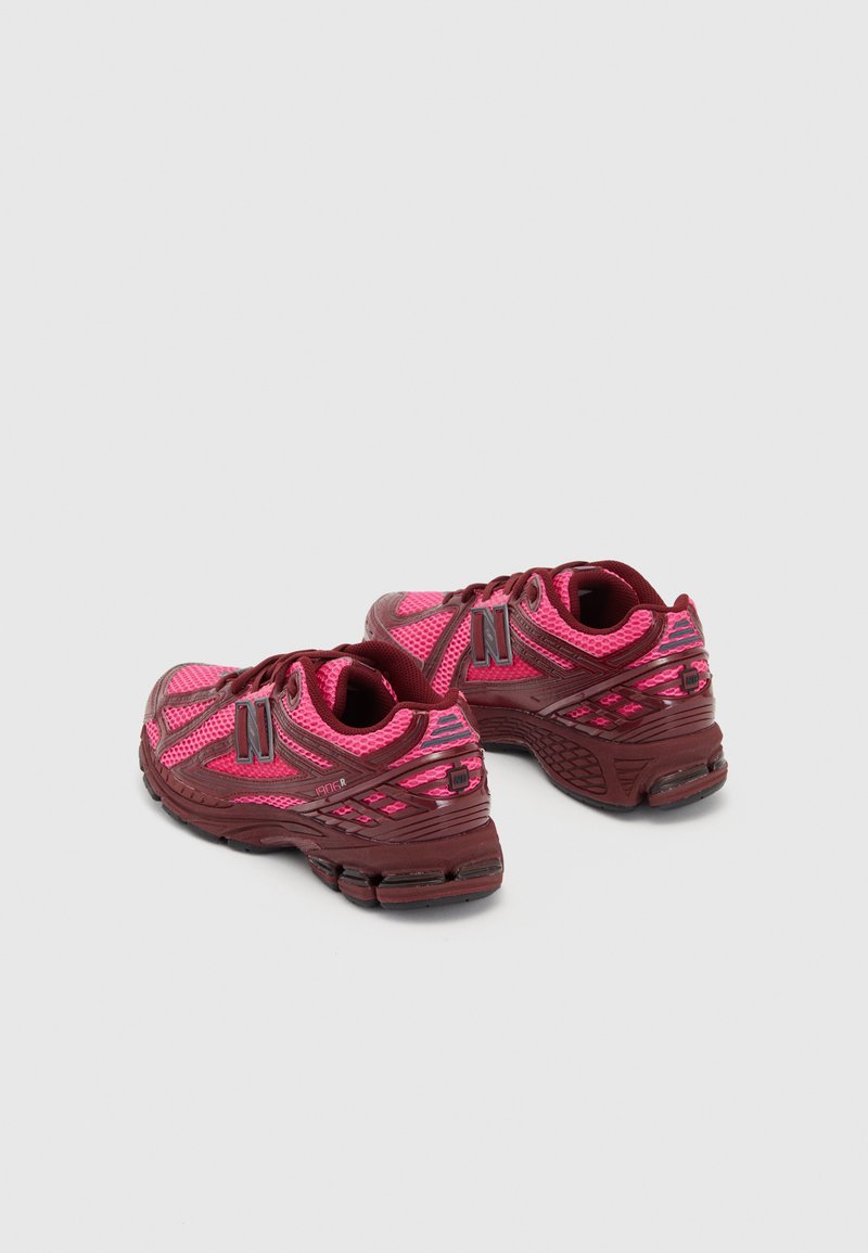 Pink and maroon athletic shoes with mesh upper, padded collar, and rubber sole. Features logo and textured accents on sides and heel.