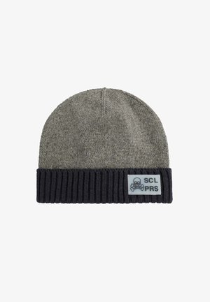 Gorro de punto en gris con puño acanalado azul marino, que presenta un parche rectangular con calavera y huesos cruzados blancos y texto "SCL PRS".