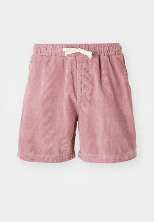 Shorts en velours côtelé rose clair avec une surface texturée, une taille élastique et un cordon blanc pour l'ajustement.