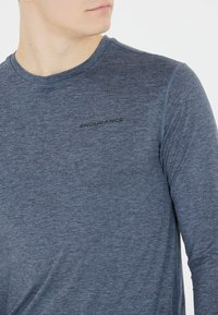 Långärmad träningströja i mörkblå heathered tyg, med rund hals och svart "ENDURANCE"-logotyp på bröstet. Snygg och mjuk textur.