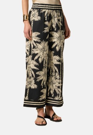 Black wide-leg pants with a cream palm tree print, featuring an elastic waistband and a horizontal striped hem. Made of lightweight fabric.
