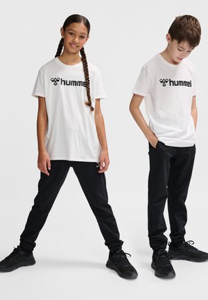 Weiße T-Shirts mit "hummel"-Logo, kombiniert mit schwarzen Sweatpants. Glattes Baumwollmaterial, lockere Passform und leichte Sportschuhe.