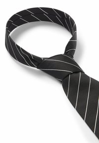 Cravate noire en tissu lisse avec des rayures blanches diagonales. La cravate a une forme classique avec une partie centrale soigneusement nouée.