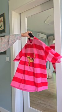 Pruhované růžové a červené tričko s krátkým rukávem, na kterém je leopardí grafika a hvězdičkový detail. Měkká látka, volný střih a kulatý výstřih.