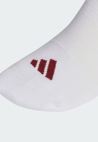 Biela ponožka z mäkkého materiálu s bordovým dizajnom troch prúžkov na oblasti členka. Hladká textúra a spevnená špička.
