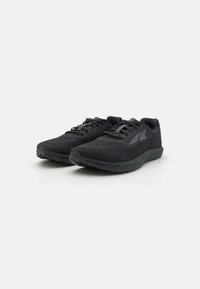 Black athletic shoes with a mesh upper, flat laces, and a textured sole. Features a minimal design and a subtle logo on the side.