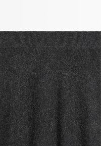 Tissu tricoté gris foncé avec une texture douce, doté d'un col côtelé et d'une finition lisse. Le design global est simple et minimaliste.