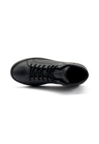 Zapatilla de piel negra con acabado suave, puntera redonda, diseño de cordones planos y cuello acolchado. Estilo minimalista sin logotipo visible.