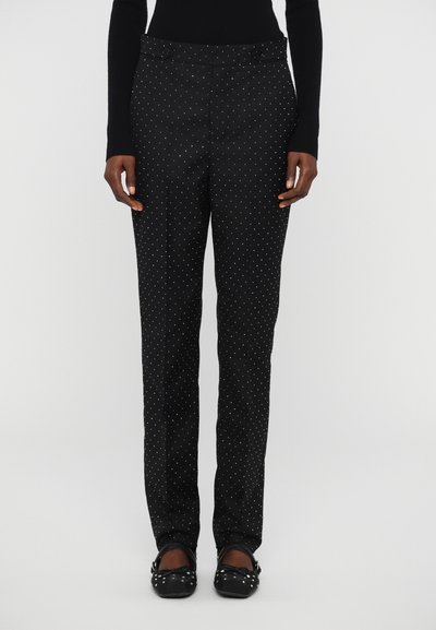Pantaloni negri cu model de buline albe, design cu picior drept, buzunare laterale și talie cu două butoane. Purtați cu pantofi plates negri.