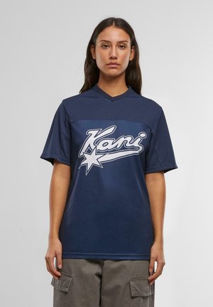 Navy-Blaues T-Shirt mit kurzen Ärmeln, V-Ausschnitt, großem weißen "Kani"-Logo und Stern-Grafik auf der Vorderseite, aus glattem Stoff gefertigt.