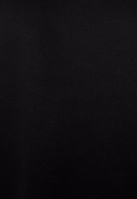 Tessuto di cotone nero con una trama liscia, che presenta un colore uniforme senza motivi o accenti.