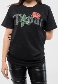 Black cotton t-shirt featuring a graphic design with silver rhinestones and a rose motif in red and green, crew neck, short sleeves.