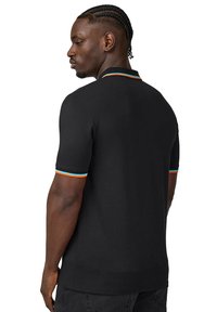 Czarna koszulka polo z krótkim rękawem i dopasowanym krojem, z kolorowymi paskami na kołnierzyku i mankietach. Gładka faktura.