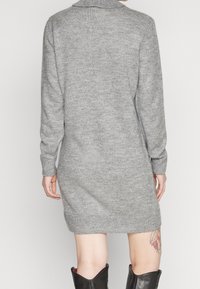 Abito maglione grigio con maniche lunghe e colletto a scialle, caratterizzato da una finitura testurizzata e polsini a costine.