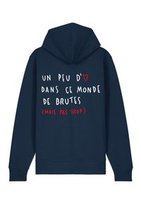 Temno modra kapuca z velikim pokrivalom, ki ima na hrbtni strani belo in rdeče besedilo. Material se zdi mehak in ima sproščen kroj.