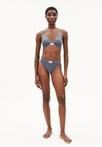 Grijze bh en bijpassende bikini slip, gemaakt van zachte stof, met een v-hals ontwerp, minimalistische snit en subtiele logo accenten.