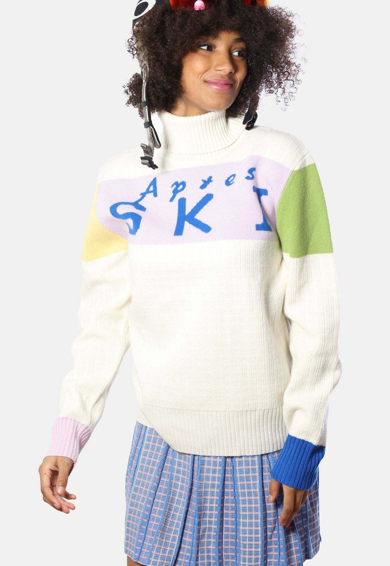 Weißer Strickpullover mit pastellfarbenen Blockstreifen in Pink, Grün, Gelb und Blau, der den Text "Apres SKI" in Blau über die Brust trägt.