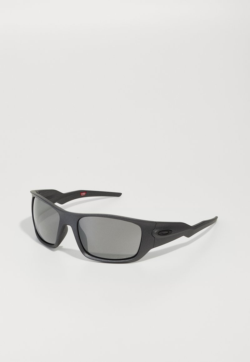 Schwarze Sonnenbrille mit matter Oberfläche, enganliegendem Design und grauen Gläsern. Verfügt über strukturierte Bügelgriffe und ein kleines Logodetail.