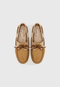 Šviesiai rudos sušalimo laivų bateliai su rudos spalvos raišteliais, siuvinėtu detalizavimu ir raštuotu vidpadžiu, ant kurio pavaizduotas Timberland logotipas.