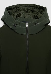 Giacca verde scuro con colletto alto imbottito, dotata di cordini regolabili e chiusura centrale con zip argentata.