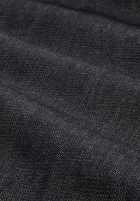 Tela oscura con una textura tejida, que muestra variaciones sutiles en el color. El aspecto general es suave con un ligero brillo.