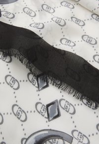 Foulard in seta con sfondo bianco, decorato da motivi a logo grigi e bordi trasparenti neri, che presenta un bordo frange e accenti geometrici.