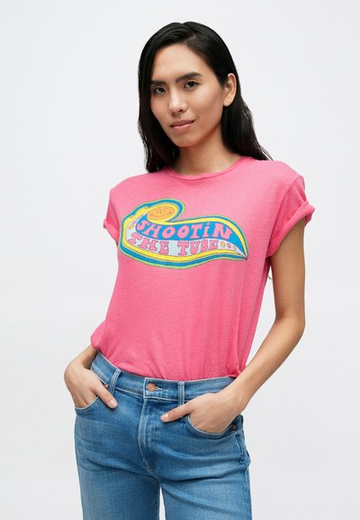 Roza majica od pamuka s šarenim natpisom "SHOOTIN' THE TUBE" i razigranim dizajnom. Opušteni kroj s kratkim rukavima urolanim na manžete.