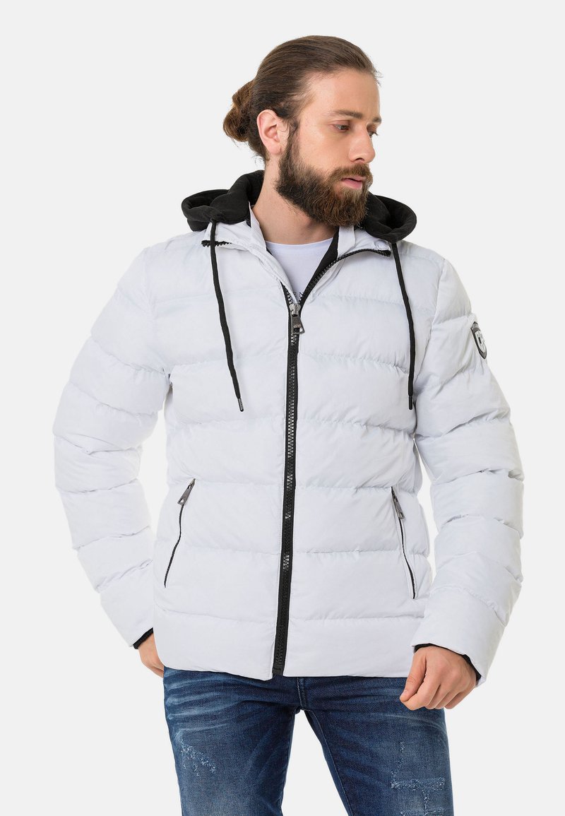 Weiße Pufferjacke mit schwarzem Akzent an der Kapuze; verfügt über einen Reißverschluss an der Vorderseite und seitliche Taschen; gestepptes Design mit sichtbaren Nähten.