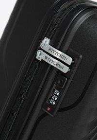 Černý kufr s tvrdou skořepinou, vybavený dvojitým zipem s brandingem "WITTC hen", vestavěným kombinovaným zámkem a texturovaným povrchem.