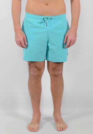 Pantaloni da bagno turchesi con vita elastica e cordoncino. Realizzati in un materiale leggero, con una texture liscia e cuciture ordinate.